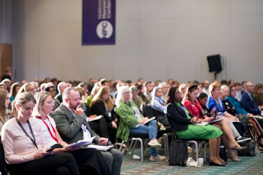 Audience seated at the National Planning Conference listening to a presentation.
