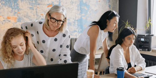 Office team looking at laptops and co-working