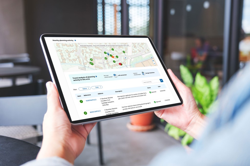 Hands using a tablet to browse interactive digital planning tools.
