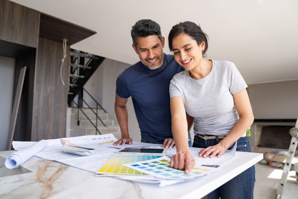 Couple reviewing renovation plans and selecting materials for the project